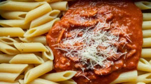 Penne and another type of pasta topped with tomato sauce and melted cheese